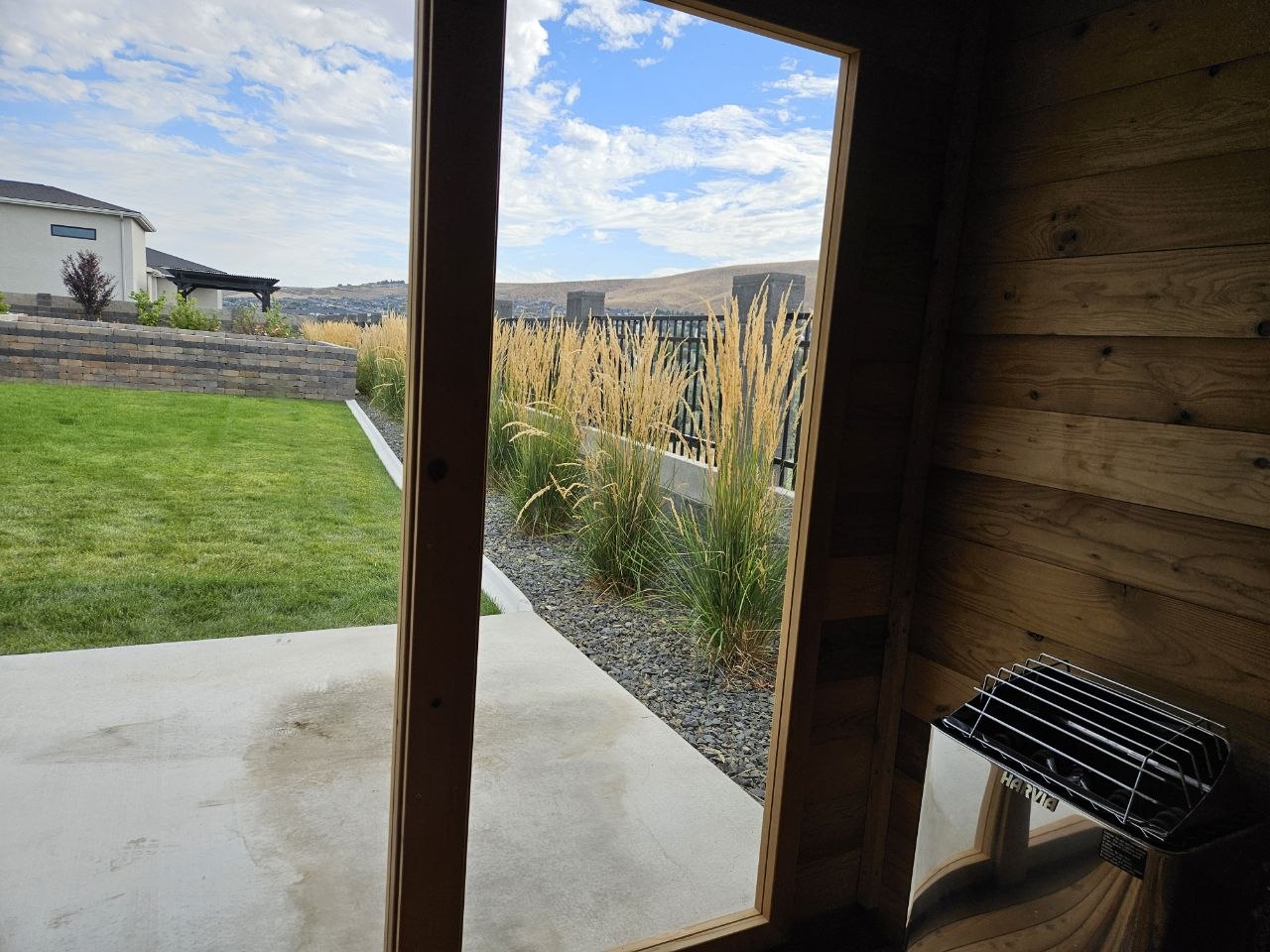 Inside cedar outdoor sauna with Harvia heater, glass door view of Tri-Cities hills and Vita Spa — AquaZen delivery Richland WA