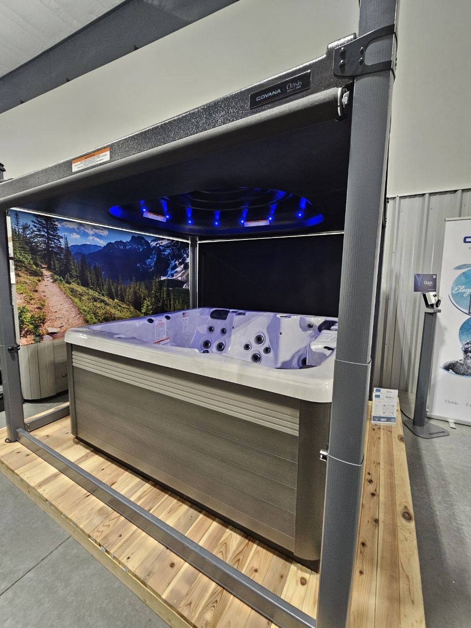 Covana Oasis automated spa cover with blue LED lighting over hot tub on custom deck — AquaZen showroom Richland WA