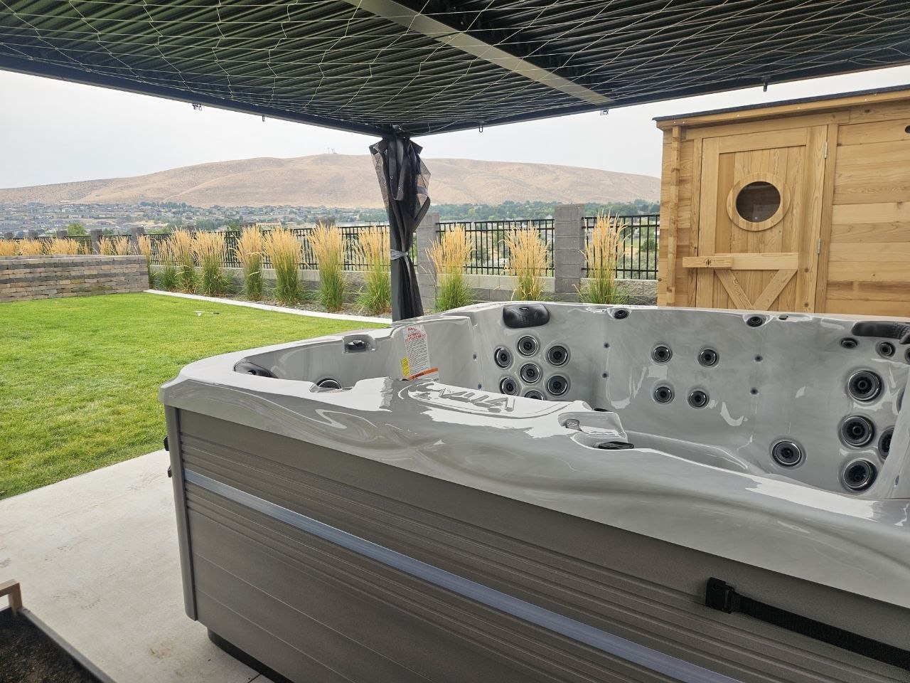 Vita Spa hot tub with Tri-Cities hills view under pergola next to cedar sauna — AquaZen Pool Spa Sauna Richland WA