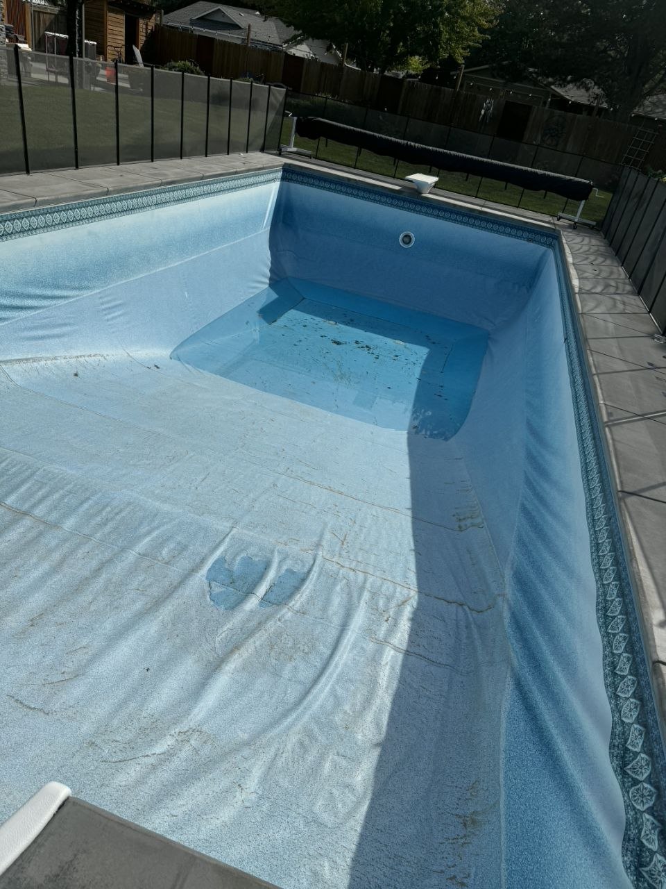 Old worn pool liner before replacement — wrinkled and faded