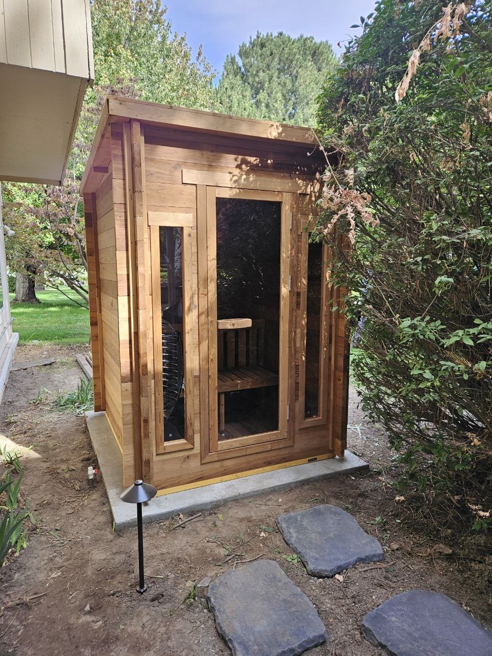 Redwood Outdoors 4-person cabin sauna installed outdoors on concrete pad — AquaZen Tri-Cities WA